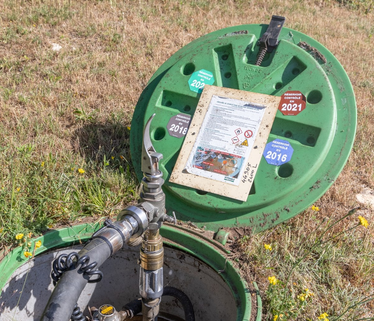 Capot ouvert d'une citerne de gaz enterrée